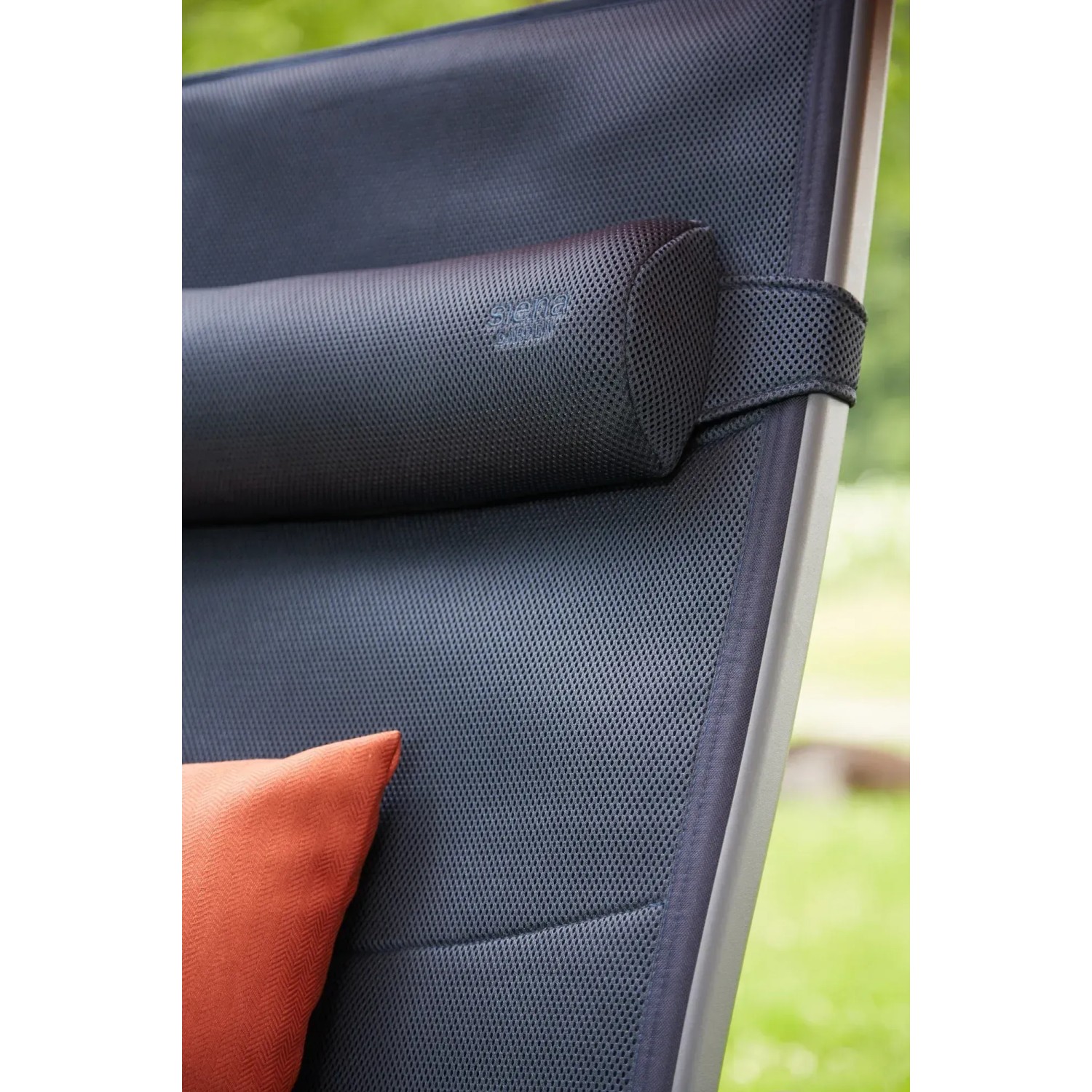 Detailaufnahme: Dunkelblaue Siena Garden Campingliege Premium XL mit Kopfkissen und orangefarbenem Kissen.