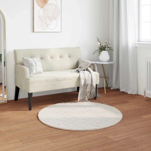 Runder, cremefarbener vidaXL Kunstfell Teppich Olite aus Polyester, Ø 120 cm, auf Holzfußboden im Wohnzimmer.