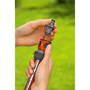 Gardena Kupplung wird an Gartenschlauch befestigt, Nahaufnahme.