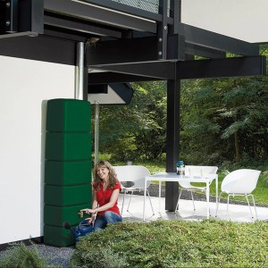 Grüner 4rain Slim Regenwassertank (330 l) mit Zubehör und Frau mit Gießkanne.