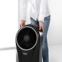 Schwarzer DeLonghi Ventilatorkühler EV250 mit Ionisator wird getragen.