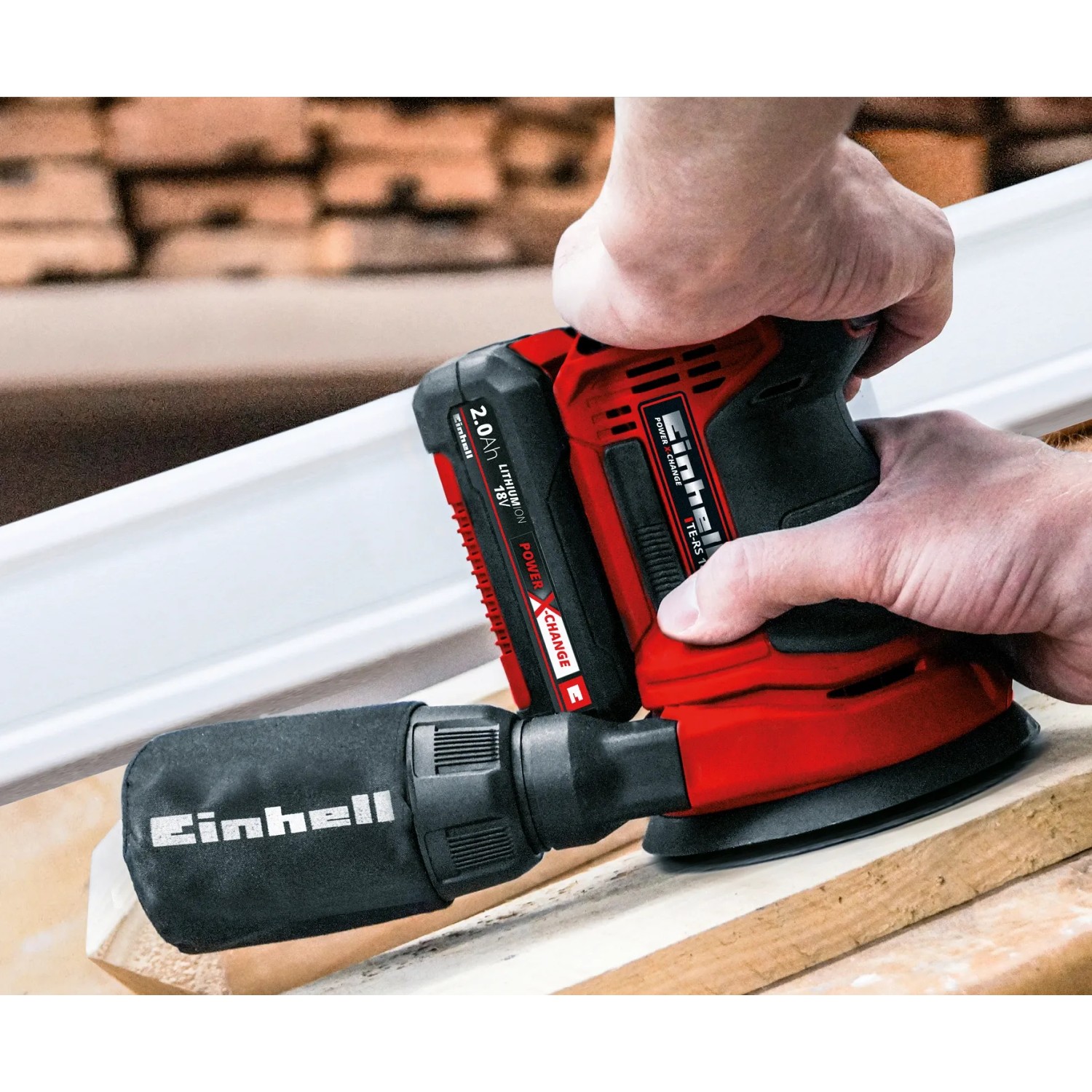 Einhell Akku-Exzenterschleifer TE-RS 18 Li mit Staubfangsack beim Schleifen von Holz.