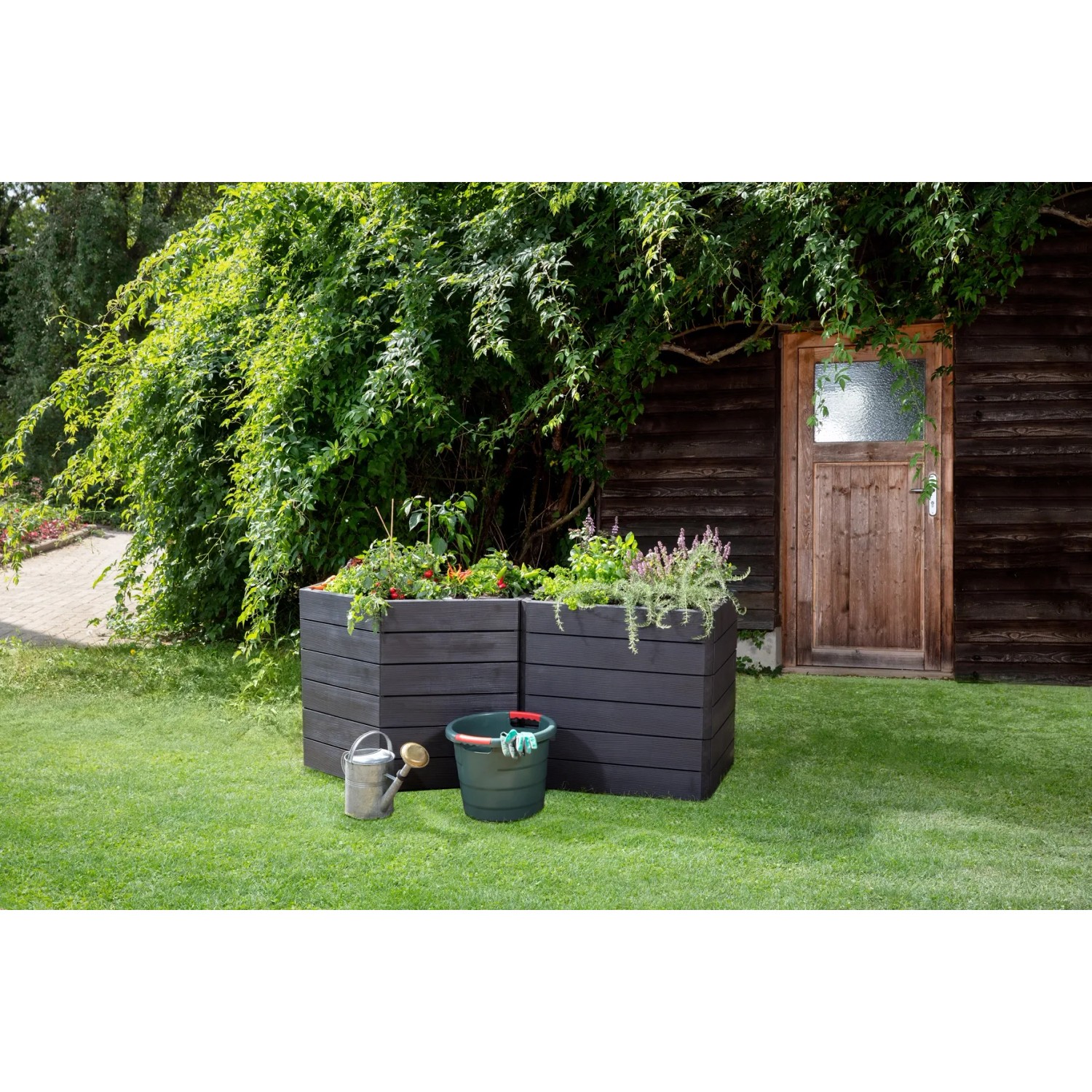 Garantia Hochbeet Ergo Vario 3 Wood im Garten mit Gießkanne und Eimer.