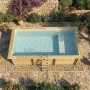 Rechteckiger ALTANKA Holzpool Aqua mit sandfarbenem Liner, Liegefläche und Holzrahmen im Garten auf Steinplatten.