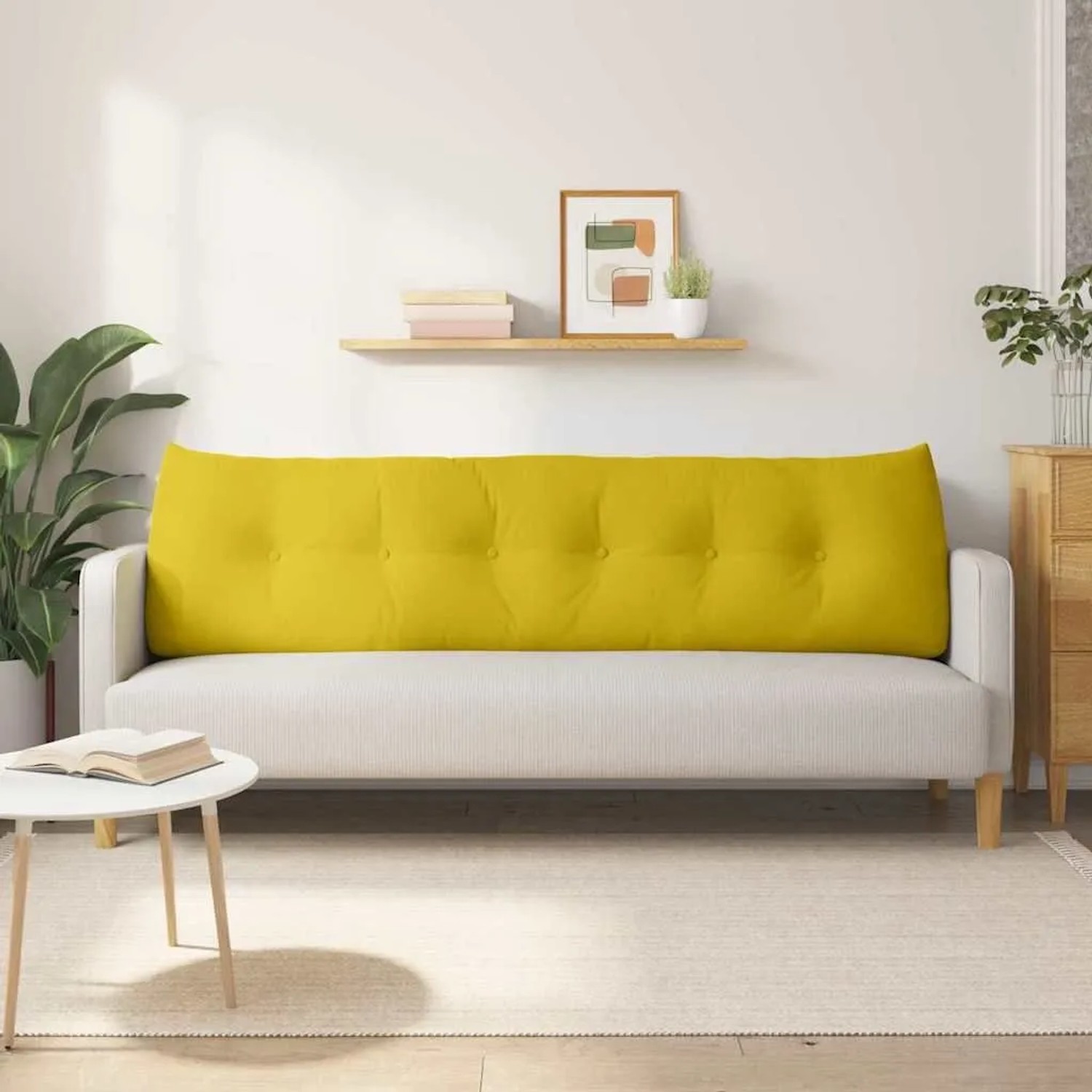 Langes gelbes Samt-Rückenkissen mit Knopfheftung auf hellem Sofa. Perfekt für Komfort im Wohnzimmer.