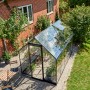 Halls Gewächshaus Qube 610, 6,4 m², schwarz, mit geöffnetem Dachfenster im Garten.