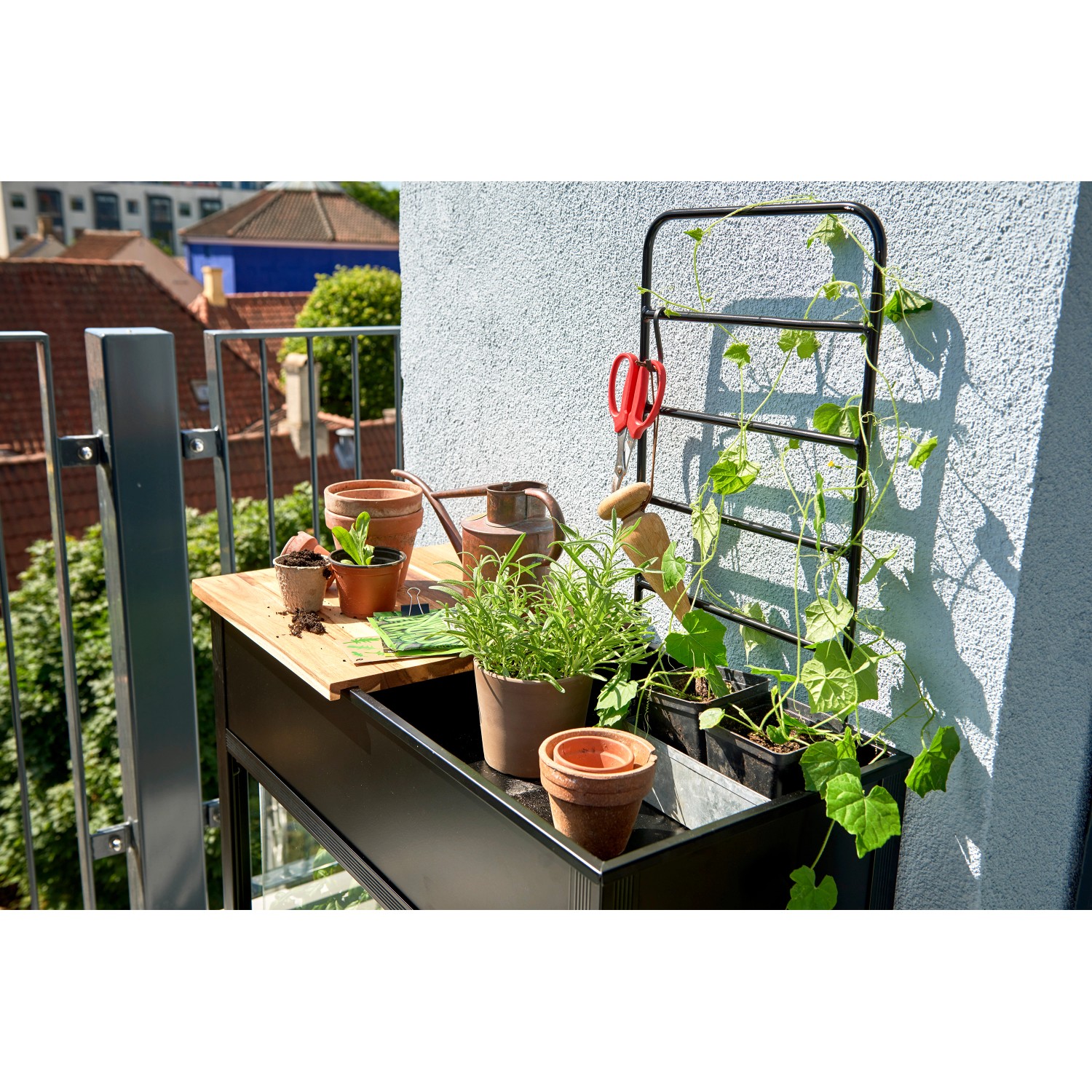 Juliana Urban Vertical Gewächshaus mit Arbeitsfläche und Rankgitter auf einem Balkon.