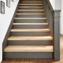 Helle Treppenstufen aus unbehandeltem Massivholz Eiche auf einer dunkelgrauen Treppe. Ideal für Renovierungen.