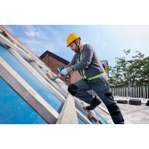Handwerker auf Dach verschraubt Holzbalken mit blauem Akku-Drehschlagschrauber GDR 18V-215 Sol.
