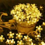 Warmweiße Solar-Lichterkette mit 20 leuchtenden Kirschblüten in einem Korb, für Garten- & Weihnachtsdeko.