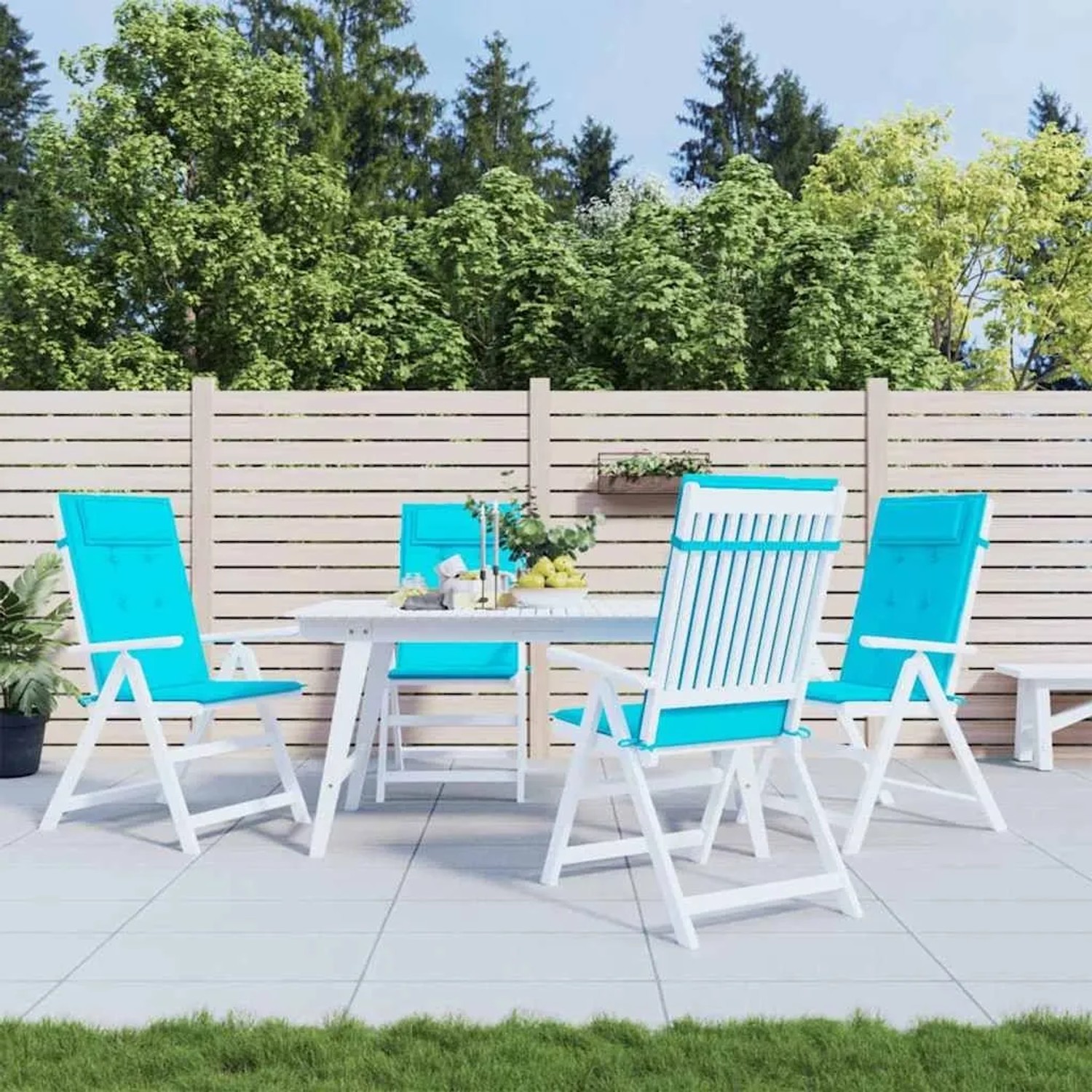 Vier türkise Hochlehner-Auflagen aus Oxford-Gewebe auf weißen Gartenstühlen für Terrasse & Garten.