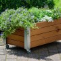 Braunes Dobar Hochbeet Rollfi aus Holz mit Rollen und Bepflanzung.