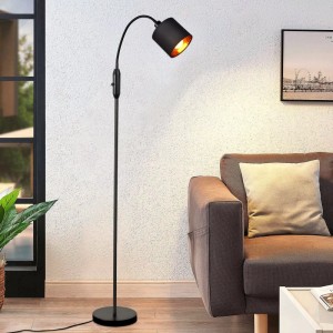 Schwarze Vintage-Stehlampe mit gebogenem Arm, schwarzem Metallschirm mit goldener Innenseite, im Wohnzimmer.