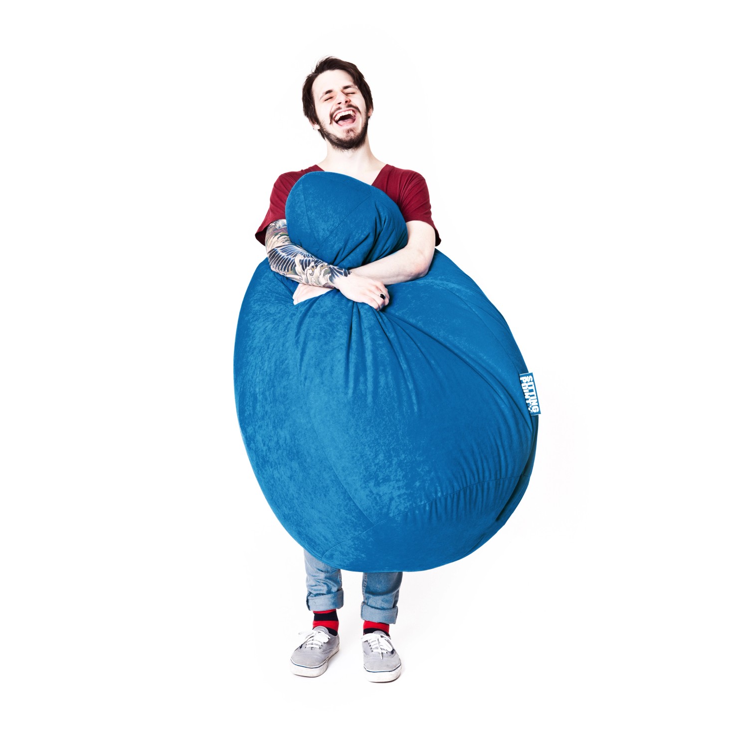 Mann umarmt grünen Sitting Point Sitzsack Easy 300 l. Gemütlicher Komfort für Zuhause.