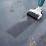 Leifheit Akku-Saugwischer Regulus Aqua PowerVac in Aktion auf Fliesen mit Fußspuren.