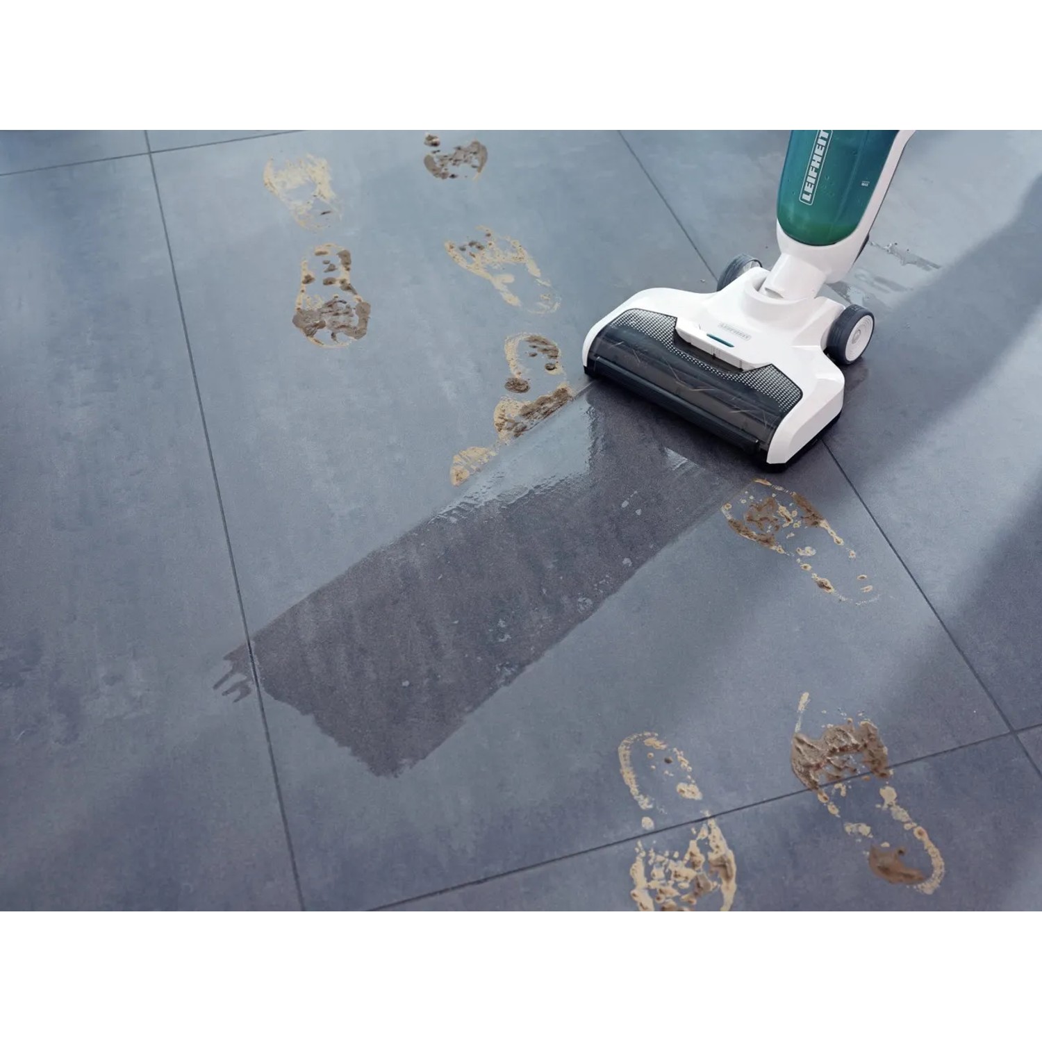Leifheit Akku-Saugwischer Regulus Aqua PowerVac in Aktion auf Fliesen mit Fußspuren.