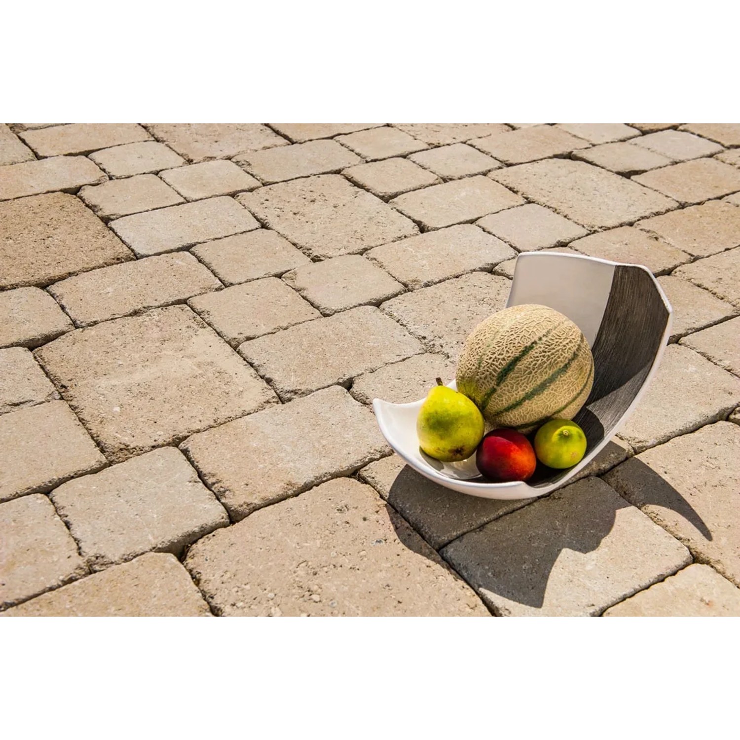 Diephaus Pflasterstein Collo Sandstein 14x14x7 cm mit Obstschale auf verlegter Fläche.
