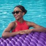 Frau entspannt auf lila Bestway Luftmatratze Float'n Roll im Pool.