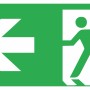 Nachleuchtendes Notausgangsschild links, 30x15 cm, grüner Hintergrund, weiße Symbole für Fluchtweg.