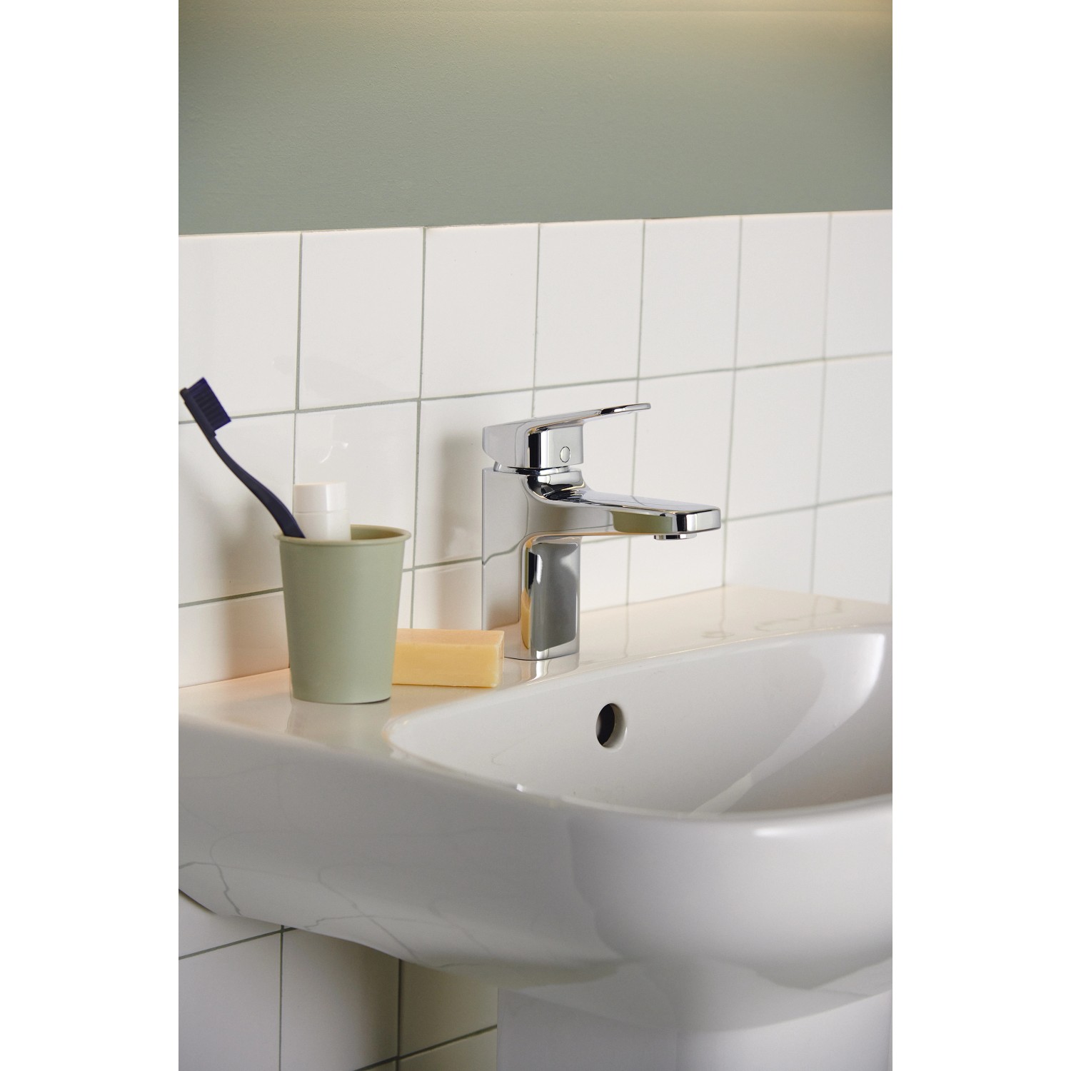 Ideal Standard Ceraplan Waschtischarmatur Chrom, H75, auf weißem Waschbecken mit Bad-Accessoires.