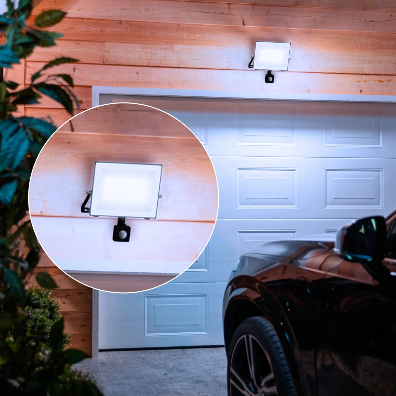Anthrazitfarbener Philips LED-Außenstrahler mit Sensor, 4500 Lumen, montiert an einer Garage.