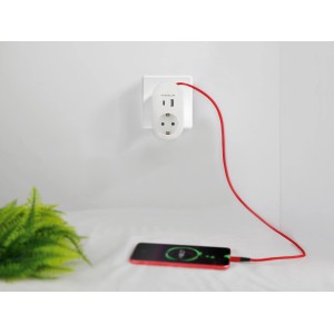 Weißer Steckdosen-Adapter mit USB-A, USB-C und Schutzkontakt-Steckdose lädt rotes Smartphone.