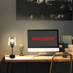 Brilo Tischleuchte Fumi mit Rauchglas auf Schreibtisch mit Deko und PC.