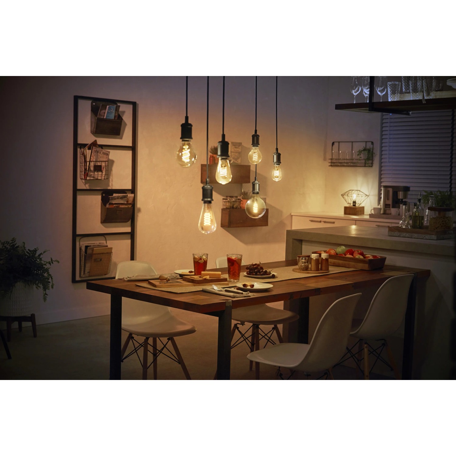 Esstisch mit mehreren, von der Decke hängenden Philips Hue Filament E27 LED-Lampen.