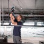 Handwerker bohrt mit Bosch Professional Bohrhammeraufsatz GFA 12-H FlexiClick in Decke.