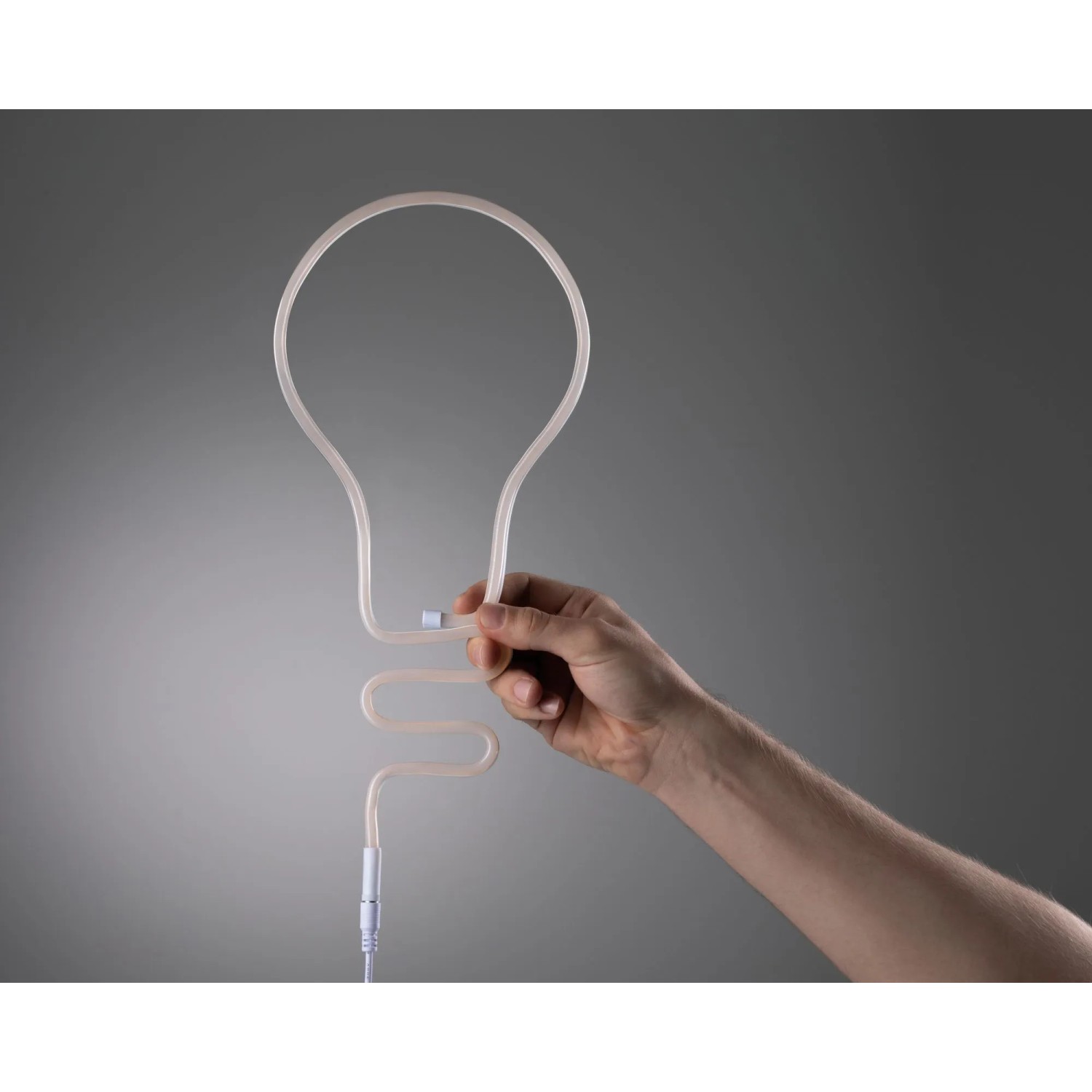 Paulmann LED Strip Neon Colorflex USB Pink, in Form einer Glühbirne von Hand gehalten.