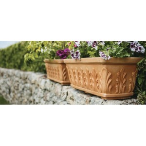 Blumentopf Mailand, Terrakotta Optik, 60cm, aus Kunststoff, mit Pflanzen auf einer Mauer.
