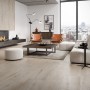 Verlegtes Cersanit Feinsteinzeug Timberfox in Holzoptik, matte Bodenfliesen im Wohnraum mit Kamin und Möbeln.