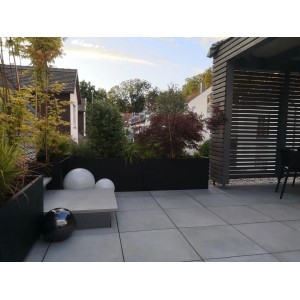Rechteckiger, schwarz-matter Fiberglas Pflanzkübel (80x30x40cm) von Elegant Einrichten auf einer Terrasse.