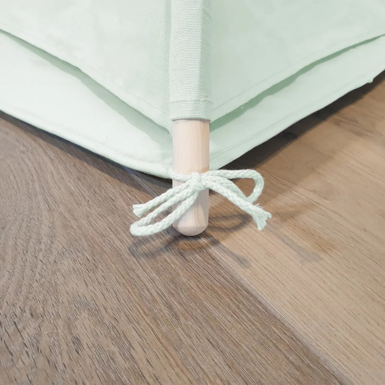 Detailaufnahme: Pastellgrünes Sunny Tipi Zelt Alba mit Holzstab und Kordel.