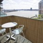 Brauner KARAT PVC Sichtschutzzaun (150x500 cm) auf Balkon mit Tisch und Stühlen.