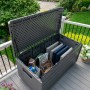 Geöffnete graue Lifetime Kissenbox 625 l mit Kissen und Spielzeug auf der Terrasse.