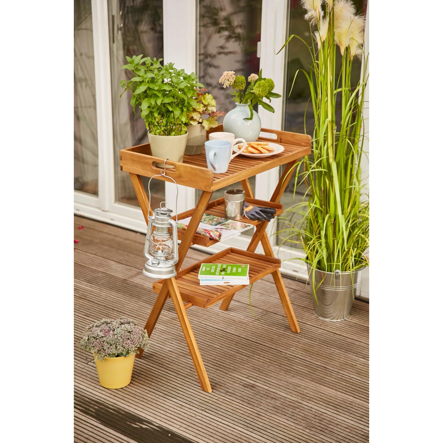 Rechteckiger, naturfarbener Siena Garden Klapptisch Caruna aus Holz, 45x70 cm, dekoriert im Außenbereich.