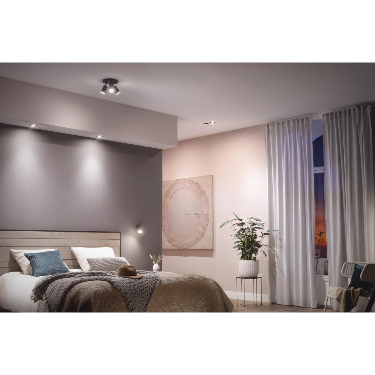 Philips Hue Centura Einbauspot, schwarz, im Schlafzimmer mit farbiger Akzentbeleuchtung.