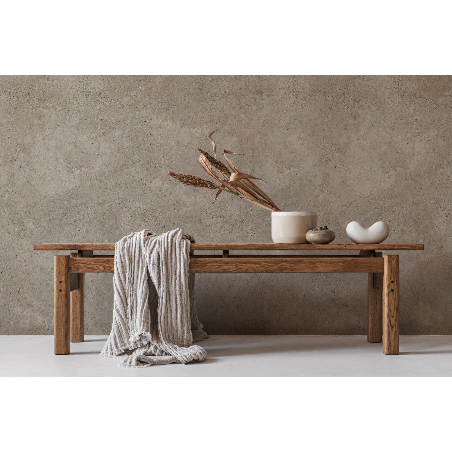 Grosfillex Wandpaneel Element 3D Optik Grigo Matt, Holzbank mit Deko und Textil vor grauer Wand.