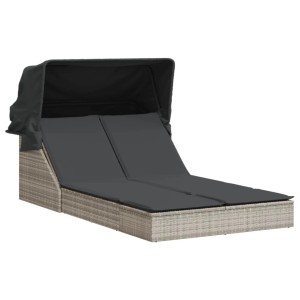 Hellgraue Doppel-Sonnenliege mit Dach und dunklen Auflagen aus Polyrattan.