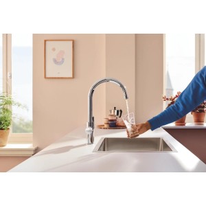 Grohe Blue Pure Start Curve Küchenarmatur-Set mit Aktivkohlefilter beim Befüllen eines Glases.