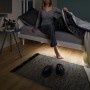 Frau sitzt auf Bett mit Paulmann LED-Strip Night Comfort Set, das den Boden beleuchtet.
