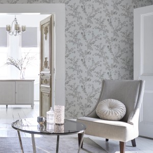 Laura Ashley Vliestapete Forsythia Steel mit zarten Blüten in stahlgrau auf weißem Grund.