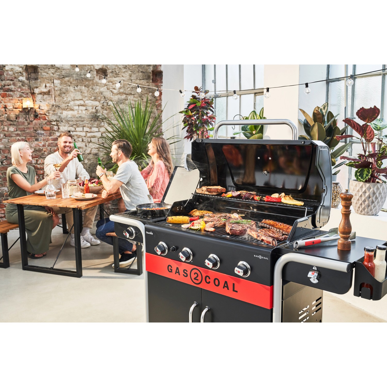 Char-Broil Gas2Coal 2.0 Hybridgrill mit 4 Brennern beim Grillen mit Freunden.