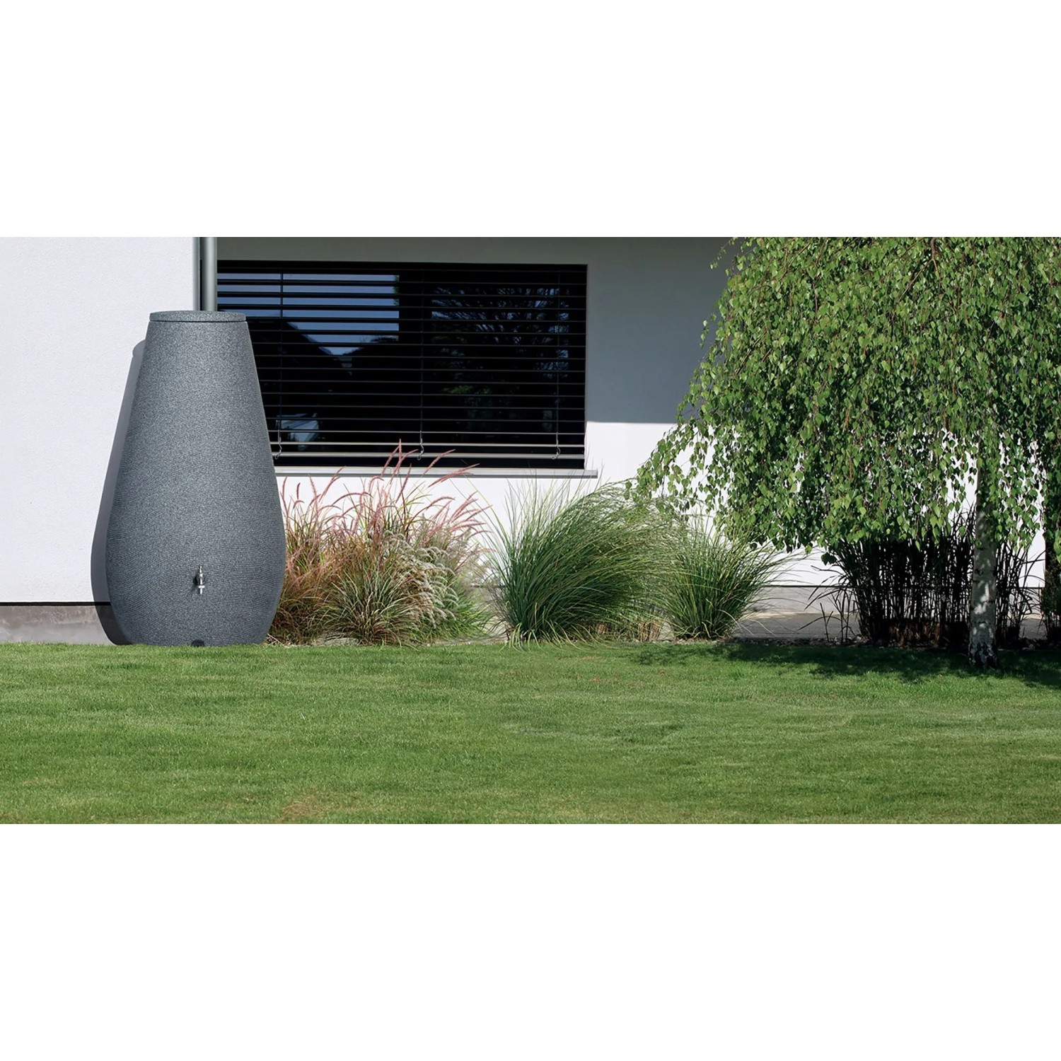 Arves Regenwassertank Drop 410 l in Granit-Optik im Garten vor Hauswand.
