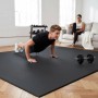 Schwarze eyepower Bodenschutzmatte im Home Gym. Mann macht Liegestütze auf stoßfester EVA-Schaummatte. Ideal für Fitness.
