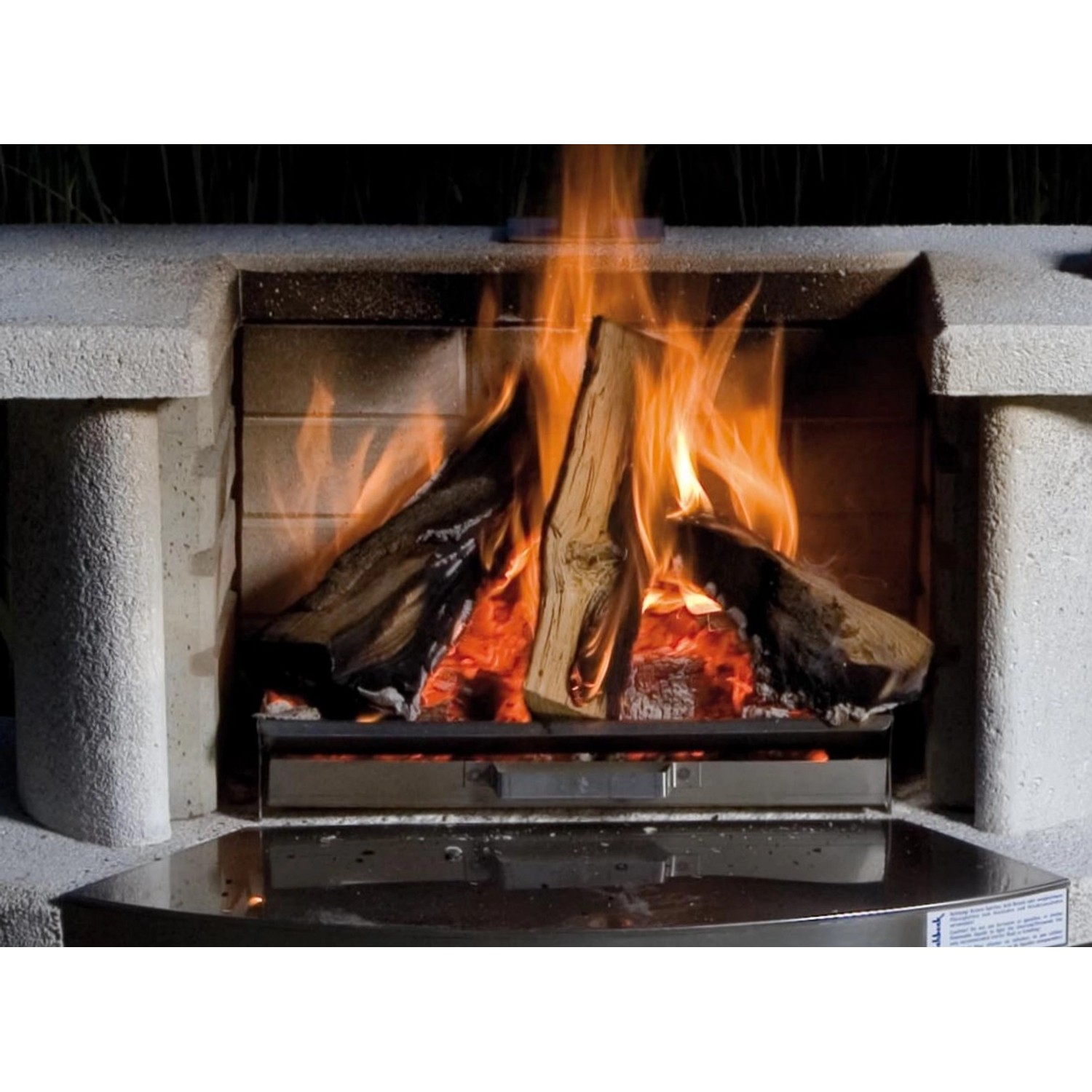 Buschbeck Feuerrost mit Aschepfanne im Einsatz mit brennendem Holz im Grillkamin.