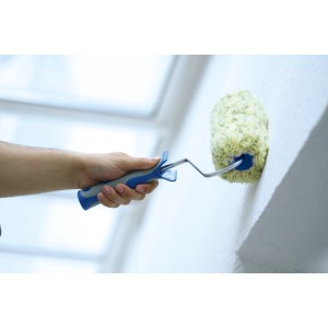 Hand streicht Wand mit LUX Polyamid Farbroller (25cm, blau/schwarz) für strukturierte Flächen.