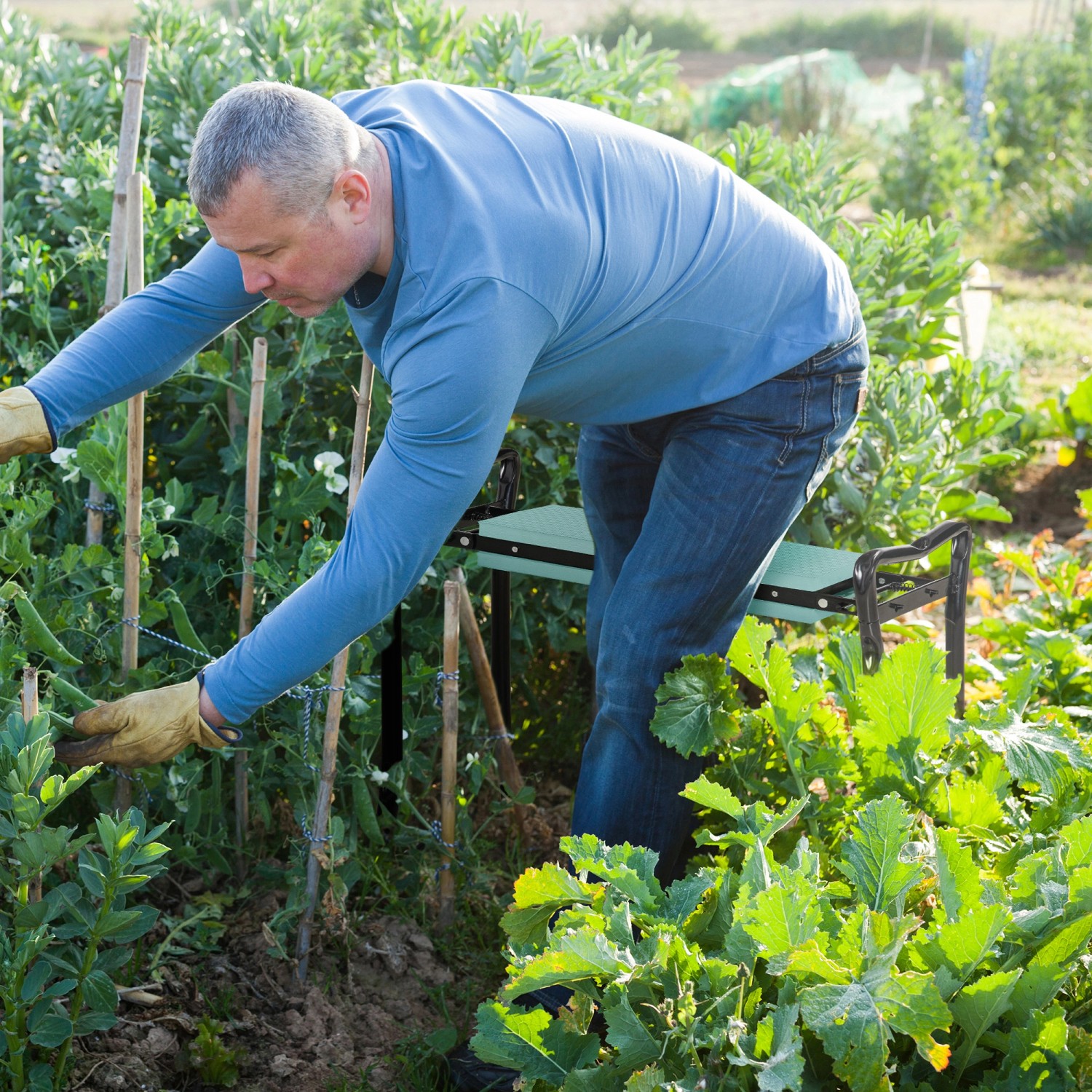 Gärtner nutzt klappbare Outsunny Kniebank in Dunkelgrün zum Arbeiten im Garten.