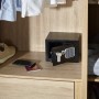 Offener, schwarzer Yale Tresor Value Safe XS mit Code im Schrank, daneben Handy und Reisepass.